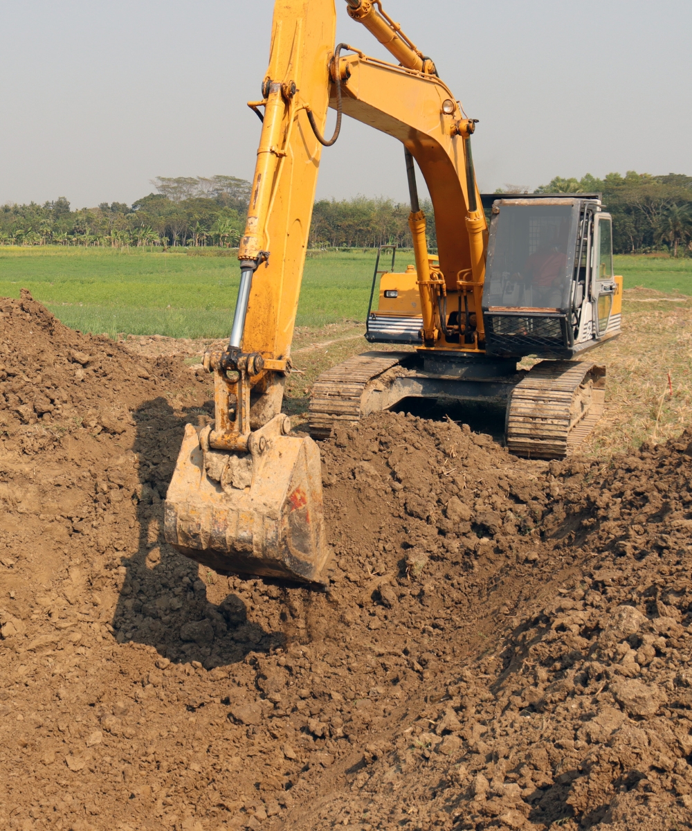 Employee excavating dirt for a land clearing project in Cross City, FL